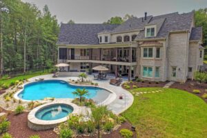 Beautiful backyard landscaping with a pool and spa surrounded by greenery.
