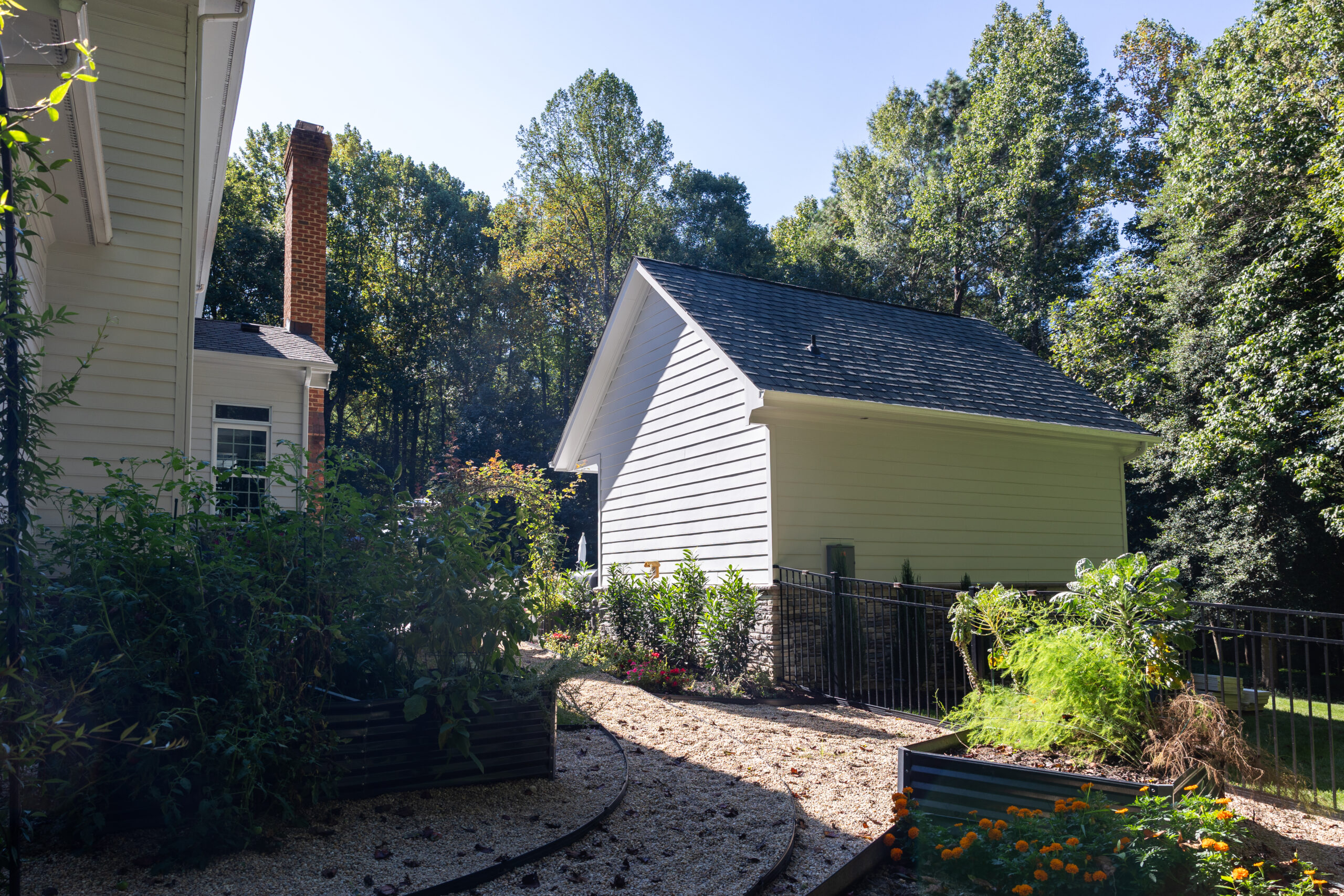 rear of pool house with beautiful garden beds